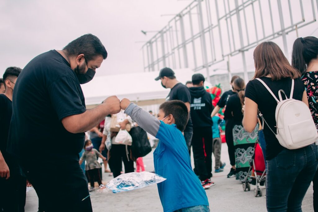 A nonprofit organizer fist bumps a child at an event.